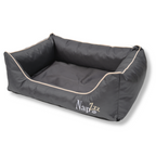 Napzzz divan waterproof antraciet in zijwaartse aanzicht. Stevige hondenmand van oxford materiaal dat waterafstotend is. De randen zijn zeer stevig gevuld met schuimvlokken voor extra steun en comfort. Uitneembare liggedeelte met schuimrubber matras. De mand is geheel voorzien van ritssluiting aan de binnenkant. Mooi afgewerkt en voorzien van napzzz logo. Verkrijgbaar in meerdere maten.