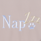 Napzzz benchkussen waterafstotend oxford stof in creme kleur op witte achtergrond afgebeeld in detail van de stof met napzzz logo. Ideaal voor hondenbenches. Verkrijgbaar in diverse maten voorzien van ritssluiting en schuimrubber matras. 