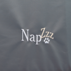  De NapZZZ Oxford Benchmat antraciet in detail met geborduurde napzzz logo. Dit is een stevig en comfortabel matras, perfect voor gebruik in hondenbenches of direct op de vloer. Gemaakt van sterke, water- en vuilafstotende Oxford stof in de kleur antraciet, geschikt voor zowel binnen- als buitengebruik. Met een dikte van 5 cm drukverlagend orthopedisch schuim biedt dit matras optimale ondersteuning aan het lichaam van je hond. 