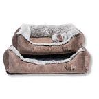 Napzzz hondenmand divan eco fluffy bruin in vooraanzicht opgestapeld in verschillende maten op witte achtergrond. Onze eco-stof is gemaakt van gerecyclede materialen. Zeer stevig gevuld met schuimvlok en ligmatras. Voorzien van afneembaar klein kussentje. Zacht pluche binnenzijde en ligmatras is omkeerbaar van bruin en langharig pluche om ander uiterlijk te geven. In diverse maten